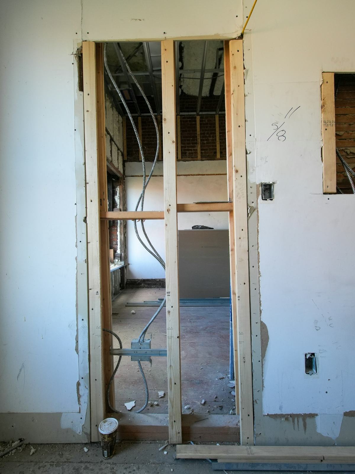 Framed door opening with exposed wood studs in a wall under renovation.