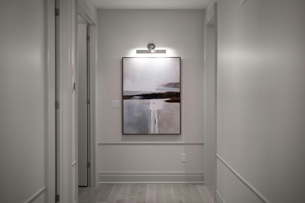 Hallway with gray walls, painted wall molding and white door casings.